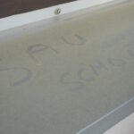 Eine Fensterbank mit gelbem Saharastaub, auf der "Sau Schön" geschrieben steht.